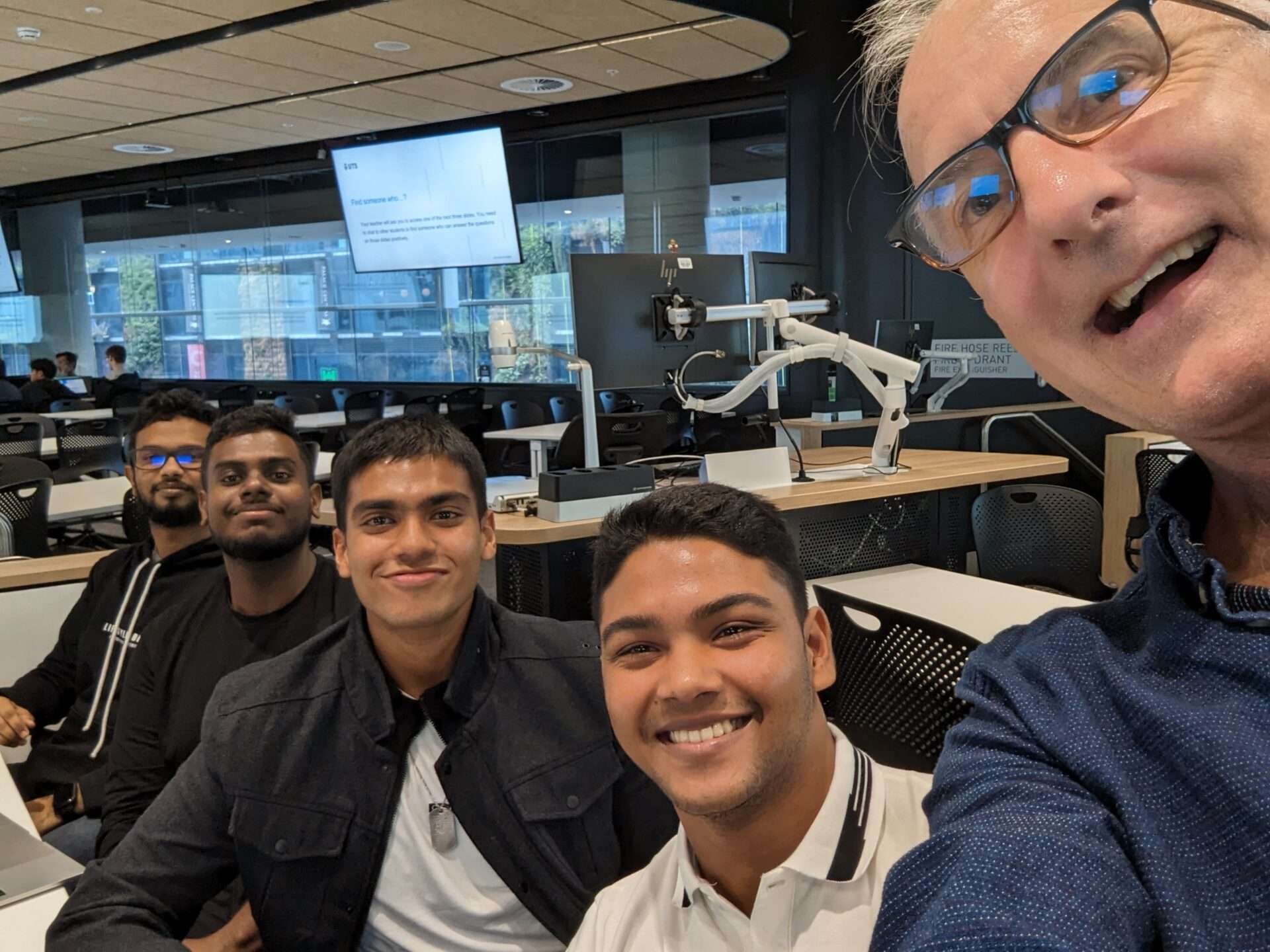Three Sri Lankan students with their lecturer in a UTS classroom in Australia